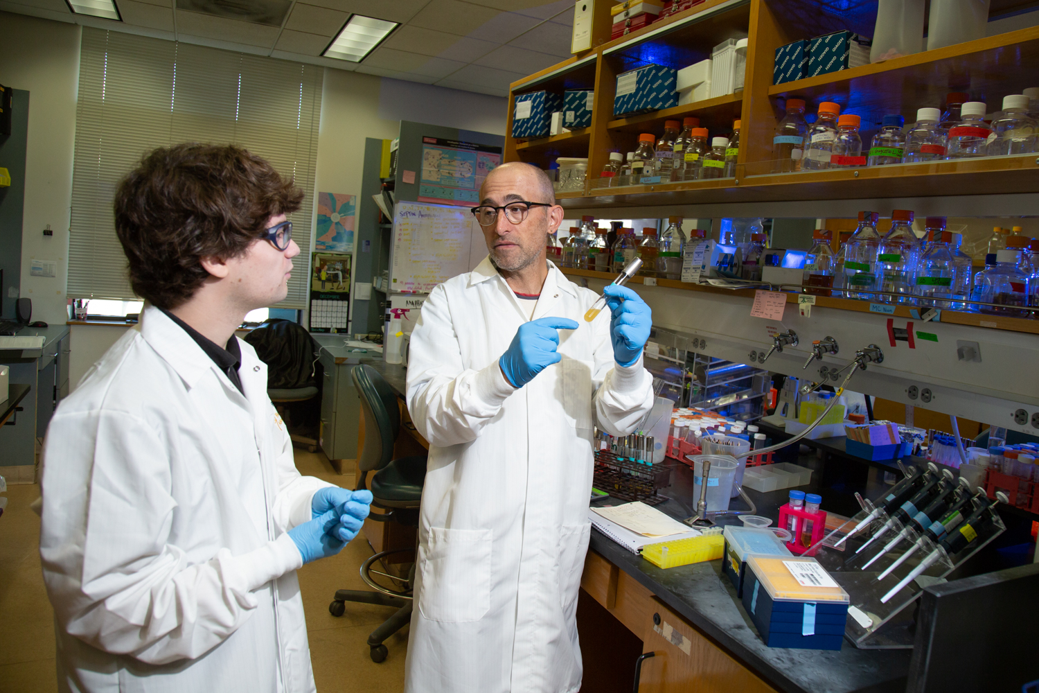 Mackenzie Noon and Professor Ken Kaplan discuss in the lab