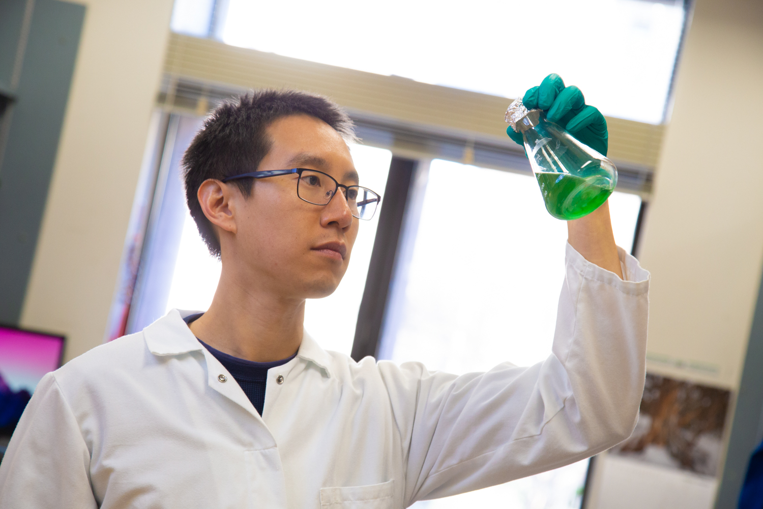 Patrick Shih looks into a beaker