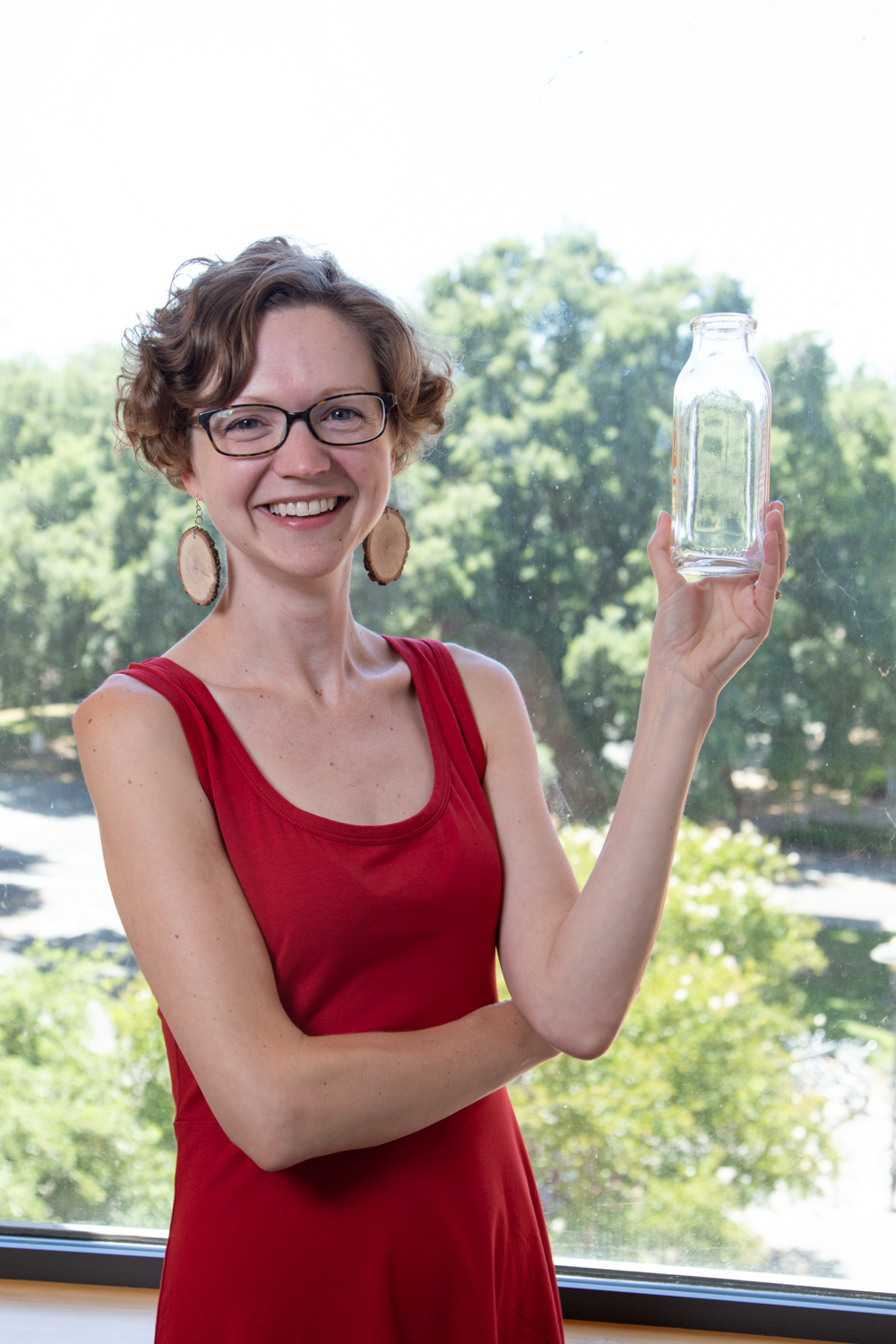 Ori-McKenney stands with a milk bottle, which used to be used to house flies in the early days of fly studies. David Slipher/UC Davis