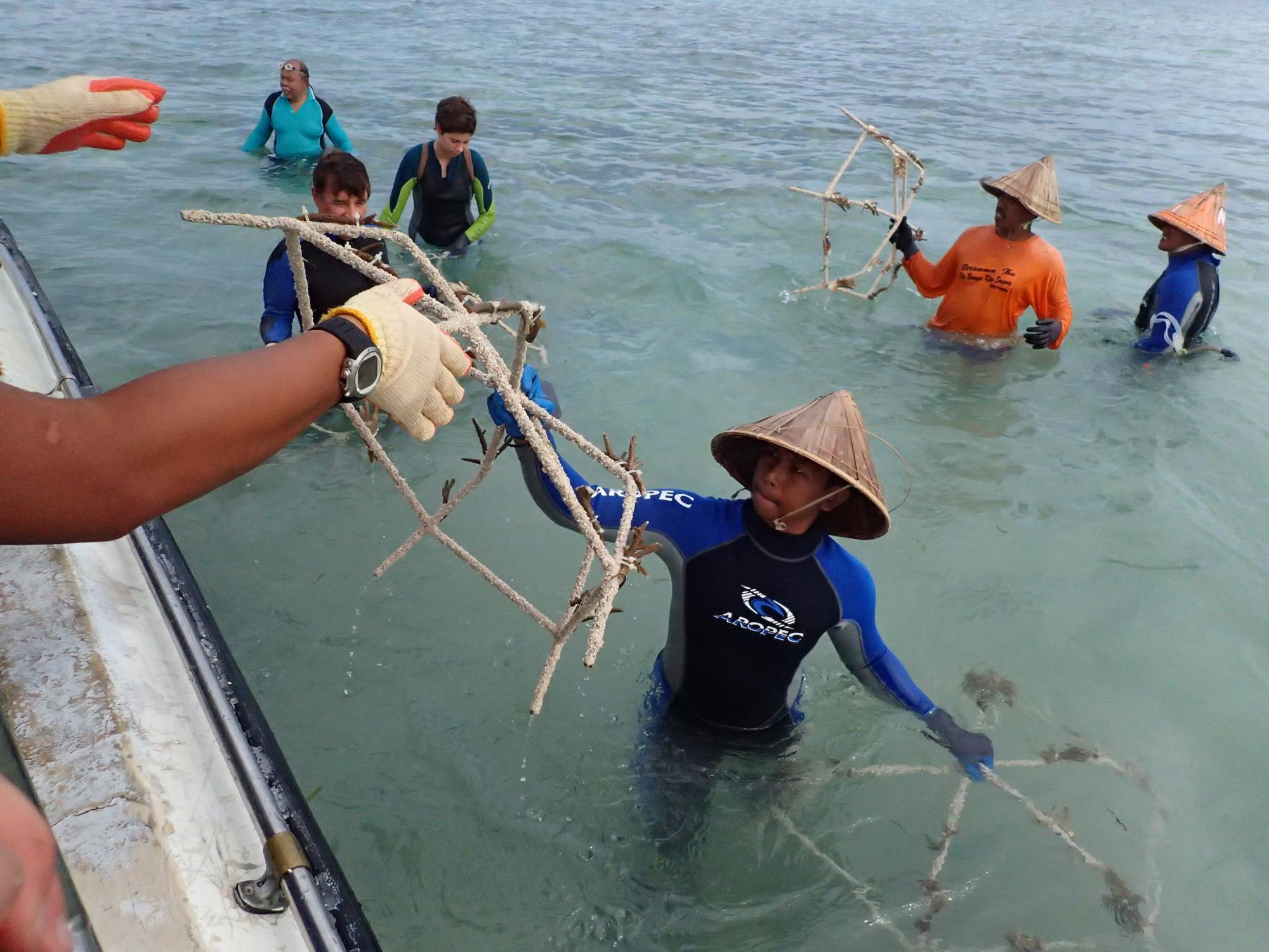 Local residents help prepare "spiders," structures for coral reef rehabilitation