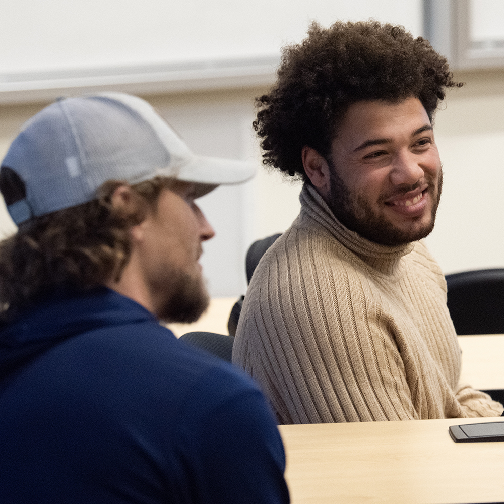 Two students in classroom smiling 