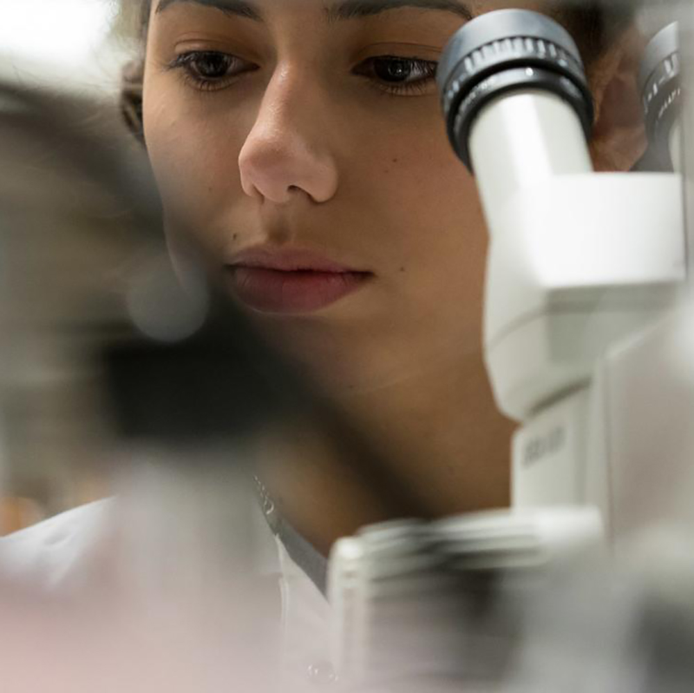 A female student and microscope close-up image