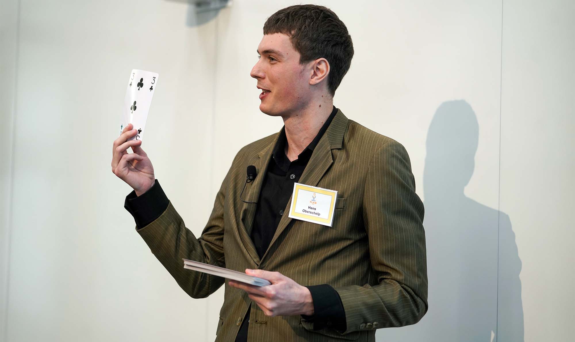 Male presenter holding a large playing card