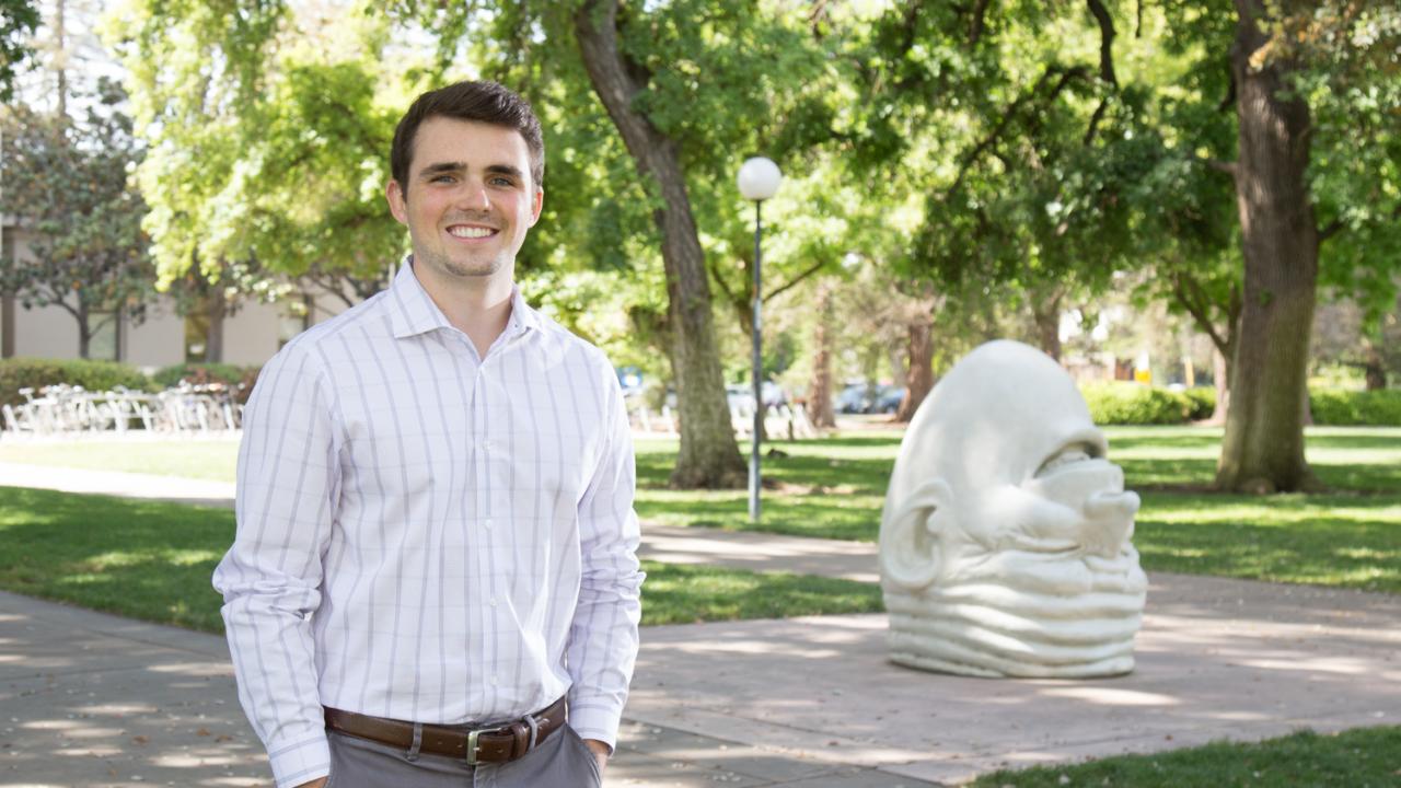 Senior Connor Grant stands next to one of UC Davis' famous Egghead statues.