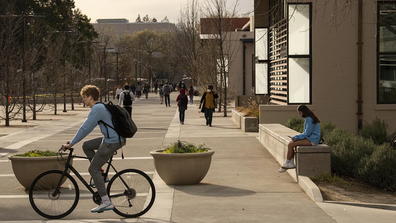 Student on bike outside Walker Hall