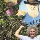 Sharon Strauss poses with an image of Charles Darwin outdoors. 