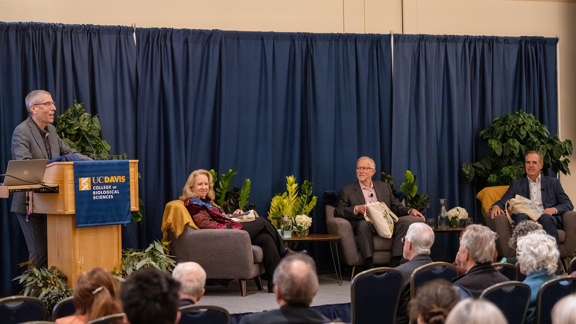After the onstage conversation, College of Biological Sciences Dean Mark Winey (left)—who connected Charles Rice (center) and Rolf Benirschke (right) for the event—presented the two alumni and Provost Mary Croughan with CBS sweatshirts (Sasha Bakhter / UC Davis)