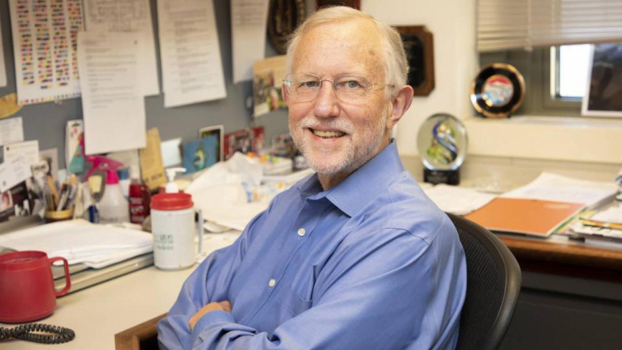 Charles Rice sits at a desk.
