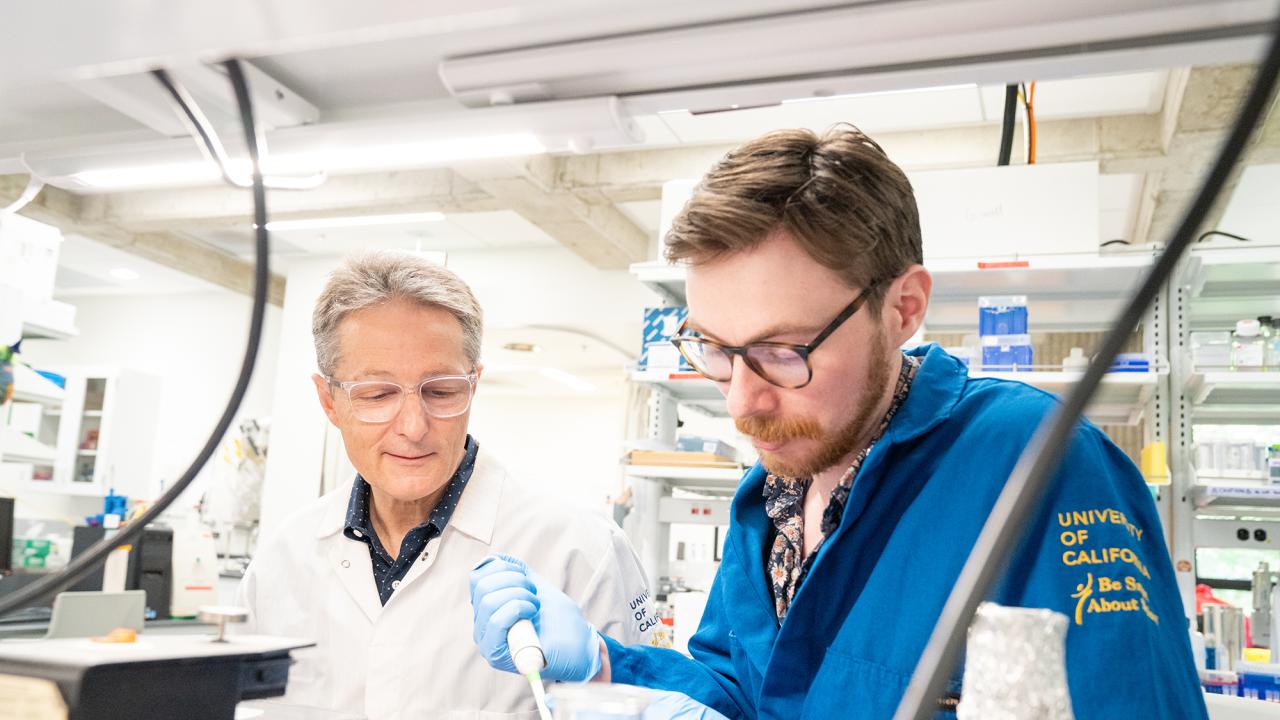 Two male researchers in a laboratory setting wearing white labcoats