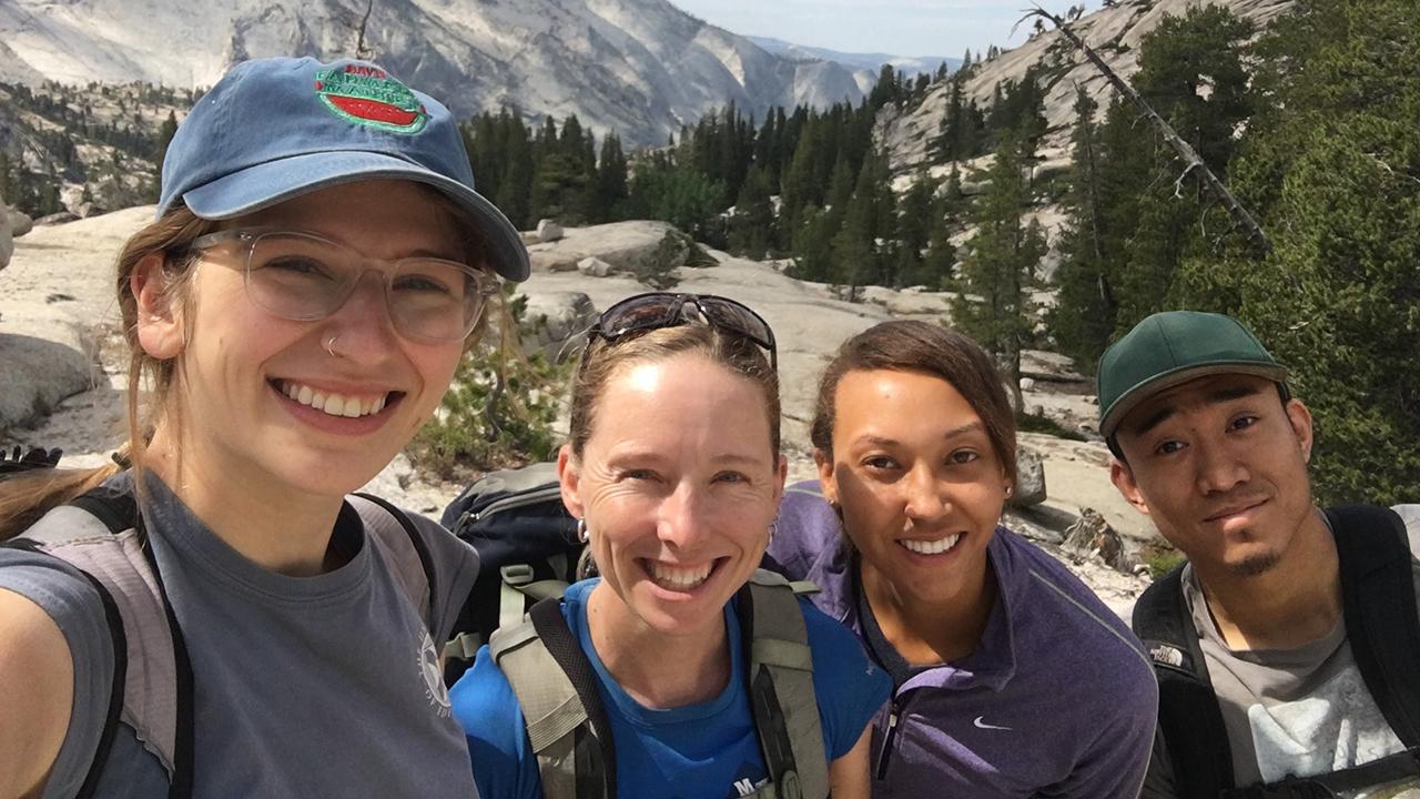 A group shot of people with mountains in the background
