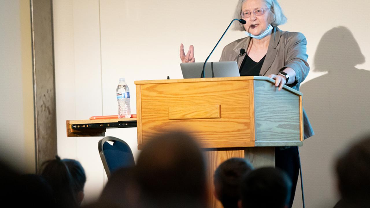 Woman at the podium speaking to a crowd