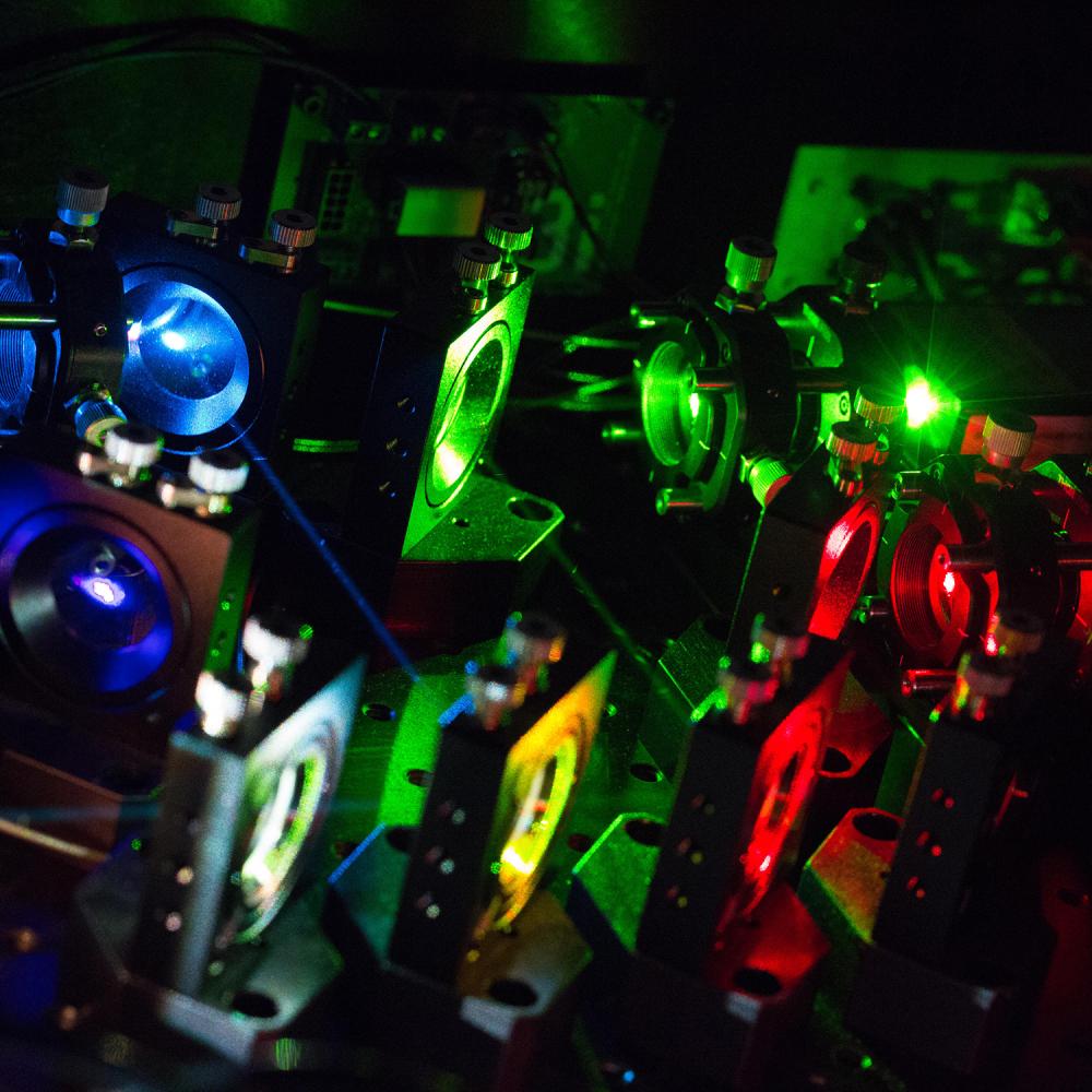 Blue, green, red, yellow lasers pointing in various directions.