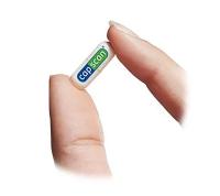 Image of cap scan capsule being held by thumb and forefinger